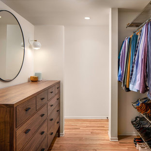 Ejemplo de armario vestidor de hombre, vintage, de tamaño medio, con armarios con paneles lisos, puertas de armario de madera en tonos medios y suelo de madera en tonos medios