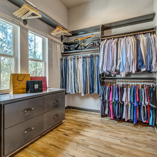 Foto di un'ampia cabina armadio unisex mediterranea con ante lisce, ante grigie, parquet chiaro e pavimento marrone