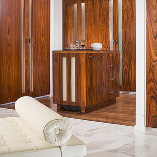 Diseño de vestidor unisex, clásico renovado, grande, con armarios con paneles lisos, puertas de armario marrones, suelo de madera oscura y suelo marrón