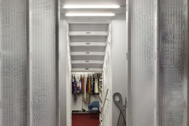Ejemplo de armario y vestidor minimalista de tamaño medio con a medida, moqueta y suelo rojo
