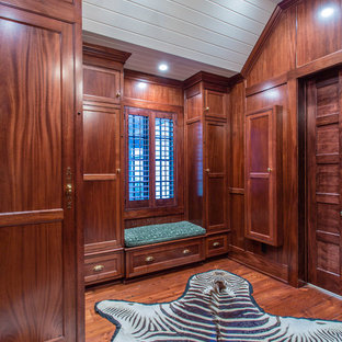 Diseño de vestidor de hombre, ecléctico, grande, con puertas de armario de madera oscura y suelo de madera en tonos medios