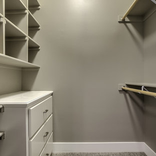 Immagine di una cabina armadio unisex classica di medie dimensioni con ante bianche, moquette, pavimento beige e ante lisce