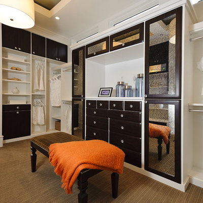 Example of a trendy walk-in closet design in Austin with dark wood cabinets