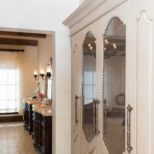Immagine di una grande cabina armadio unisex mediterranea con ante con riquadro incassato e ante marroni