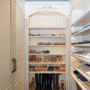 Foto di una grande cabina armadio per donna mediterranea con ante con riquadro incassato, ante beige, parquet scuro e pavimento bianco