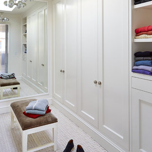 Immagine di una grande cabina armadio unisex classica con ante con riquadro incassato, ante bianche e moquette