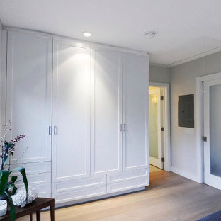 Idee per un armadio incassato unisex costiero di medie dimensioni con ante in stile shaker, ante bianche, parquet chiaro e pavimento beige