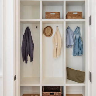 Esempio di una cabina armadio stile marinaro con pavimento beige