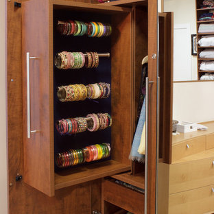 Ispirazione per una cabina armadio per donna design di medie dimensioni con ante lisce, ante in legno scuro e parquet chiaro