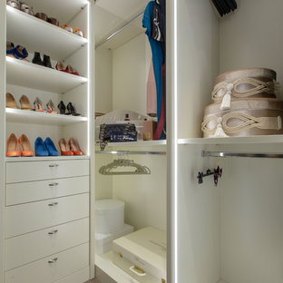 Foto de armario vestidor unisex, ecléctico, grande, con armarios tipo vitrina, puertas de armario blancas, suelo de madera en tonos medios y suelo beige