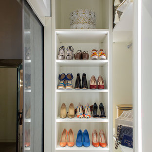 Foto de armario vestidor unisex, ecléctico, grande, con armarios tipo vitrina, puertas de armario blancas, suelo de madera en tonos medios y suelo beige