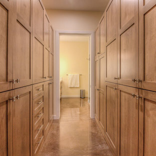 Ejemplo de armario y vestidor unisex, tradicional, con armarios estilo shaker, puertas de armario de madera oscura, suelo de cemento y suelo marrón