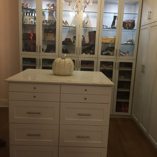 Imagen de armario vestidor de mujer, romántico, grande, con armarios estilo shaker, puertas de armario blancas y suelo marrón
