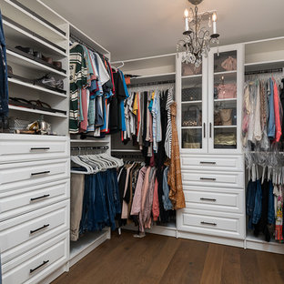 Mid-sized farmhouse gender-neutral medium tone wood floor and brown floor walk-in closet photo in Other with raised-panel cabinets and white cabinets