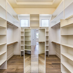 Ejemplo de vestidor clásico renovado, grande, con armarios abiertos, puertas de armario blancas, suelo de madera oscura y suelo marrón