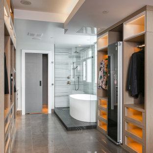 Ispirazione per un'ampia cabina armadio unisex minimal con ante di vetro, ante in legno chiaro, pavimento in cemento e pavimento nero