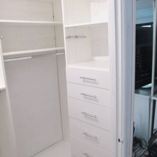 Immagine di una piccola cabina armadio unisex minimalista con ante lisce e ante bianche