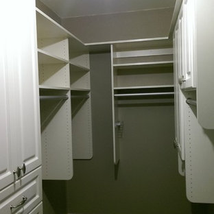 Immagine di una piccola cabina armadio unisex tradizionale con ante bianche, parquet scuro, ante con riquadro incassato e pavimento marrone