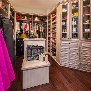 Idee per una grande cabina armadio per donna mediterranea con ante con bugna sagomata, ante in legno chiaro e parquet scuro