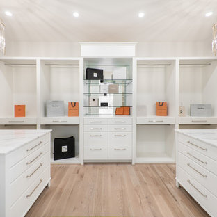 Imagen de armario vestidor unisex, contemporáneo, extra grande, con armarios con paneles lisos, puertas de armario blancas, suelo de madera clara y suelo beige