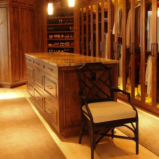 Imagen de armario vestidor unisex, ecléctico, extra grande, con armarios con paneles con relieve, puertas de armario de madera oscura y suelo de madera clara