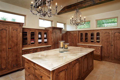 This is an example of a large rustic gender neutral dressing room in Kansas City with glass-front cabinets.