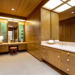 Imagen de vestidor unisex, retro, extra grande, con armarios con paneles lisos, puertas de armario de madera oscura, moqueta y suelo beige