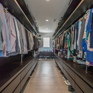 Idee per un'ampia cabina armadio unisex design con ante lisce, ante in legno bruno, pavimento in gres porcellanato e pavimento marrone