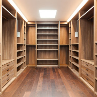 Idee per un grande spazio per vestirsi unisex american style con ante lisce, ante in legno scuro, pavimento in legno massello medio e pavimento marrone