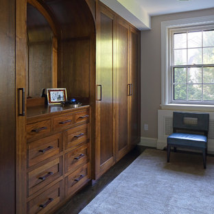 Modelo de armario vestidor unisex, clásico renovado, grande, con armarios estilo shaker, puertas de armario de madera en tonos medios y suelo de madera oscura