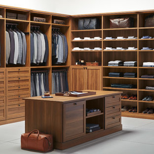 Diseño de armario vestidor de hombre, clásico renovado, con armarios estilo shaker, puertas de armario de madera oscura y suelo de cemento
