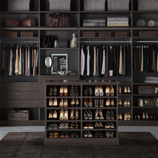 Ispirazione per una cabina armadio unisex design con ante lisce, ante in legno bruno e pavimento in cemento