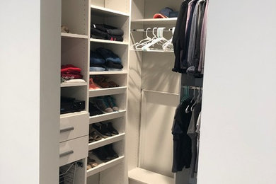 Imagen de armario vestidor de mujer minimalista pequeño con armarios con paneles lisos, puertas de armario blancas, moqueta y suelo gris