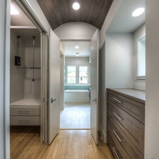 Foto di una grande cabina armadio unisex contemporanea con ante in stile shaker, ante con finitura invecchiata e parquet chiaro