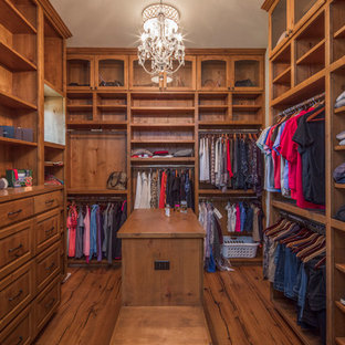 Foto di una grande cabina armadio per donna mediterranea con ante con bugna sagomata, ante in legno chiaro e parquet chiaro
