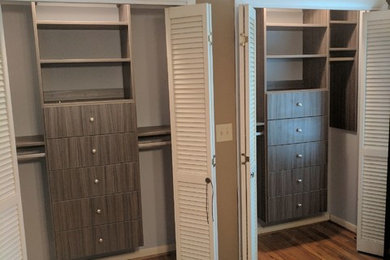 Diseño de armario y vestidor contemporáneo pequeño con armarios con paneles lisos, puertas de armario de madera oscura y suelo de madera en tonos medios