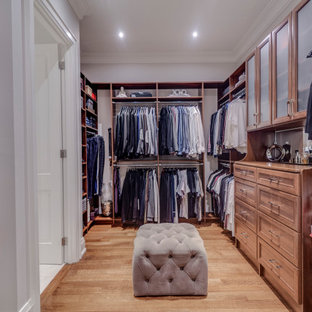 Modelo de armario vestidor unisex, clásico renovado, con armarios estilo shaker, puertas de armario marrones, suelo de madera en tonos medios y suelo marrón