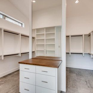 Immagine di una grande cabina armadio unisex minimalista con pavimento con piastrelle in ceramica, pavimento grigio e soffitto in perlinato