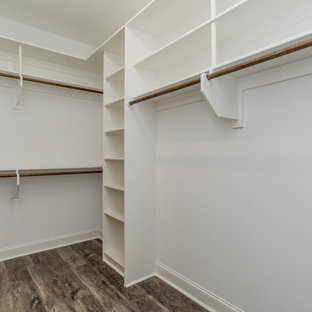 Immagine di una cabina armadio unisex tradizionale di medie dimensioni con ante bianche, pavimento in vinile e pavimento multicolore