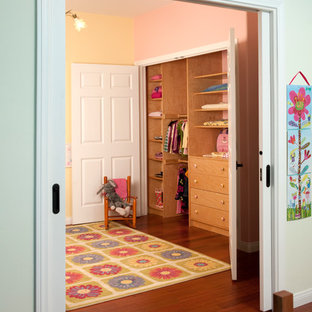 Immagine di armadi e cabine armadio per donna boho chic di medie dimensioni con ante lisce, ante in legno chiaro e pavimento in legno massello medio