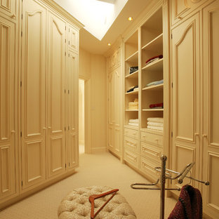 Diseño de vestidor tradicional con armarios con paneles empotrados y puertas de armario beige