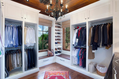 Foto de armario y vestidor clásico con armarios con paneles con relieve, puertas de armario blancas y suelo de madera en tonos medios