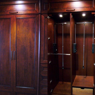 Ispirazione per una cabina armadio unisex chic di medie dimensioni con ante con riquadro incassato, ante in legno scuro e moquette