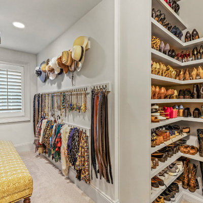 Inspiration for a large timeless gender-neutral carpeted and beige floor walk-in closet remodel in Cleveland with recessed-panel cabinets and white cabinets