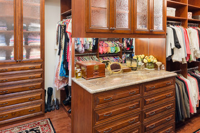 Example of a classic gender-neutral brown floor closet design in Richmond with raised-panel cabinets and medium tone wood cabinets