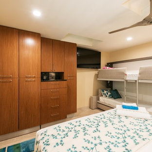 Esempio di armadi e cabine armadio tropicali con ante lisce, ante in legno scuro, pavimento in pietra calcarea e pavimento beige