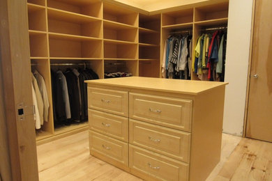 Inspiration for a large traditional gender neutral walk-in wardrobe in Birmingham with raised-panel cabinets, light wood cabinets, light hardwood flooring and brown floors.