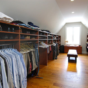 Idee per un'ampia cabina armadio unisex classica con nessun'anta, ante in legno bruno e pavimento in legno massello medio