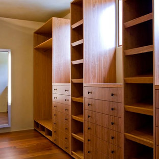 Foto de vestidor tropical, extra grande, con armarios con paneles con relieve, puertas de armario de madera en tonos medios, suelo de madera oscura y suelo marrón