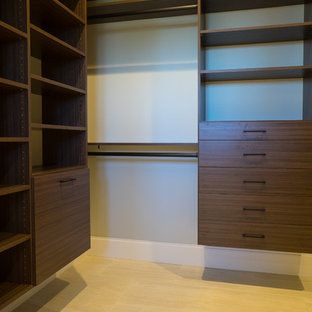 Foto di un grande armadio o armadio a muro unisex mediterraneo con ante lisce, ante in legno bruno, pavimento in pietra calcarea e pavimento beige